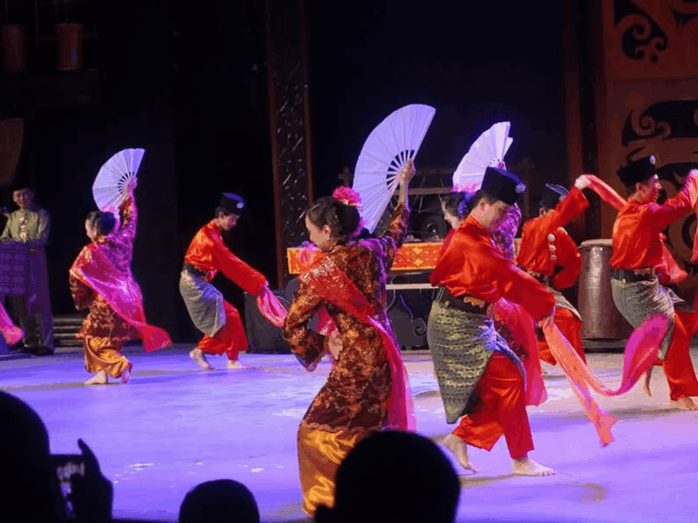 ladies and gentelment in malay tranditional costume performing dance on stage